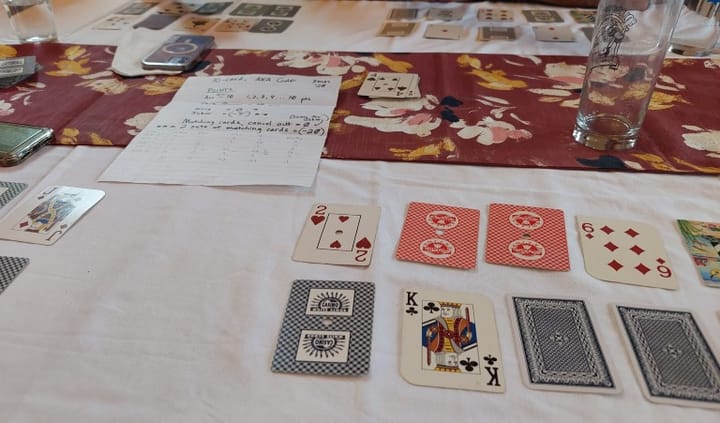 Playing cards arrayed on a dining room table.